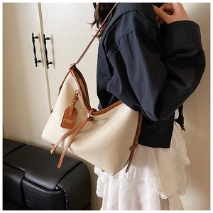 Détails du grand sac cabas avec pompons en cuir marron et texture à grain lisse élégant