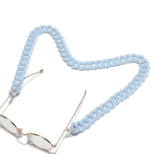 Detailed view of light blue acrylic chain links on gold metal frame glasses