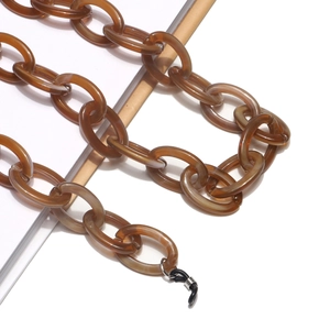 Close-up of amber acrylic chain links for eyewear with marbled texture and rubber loops