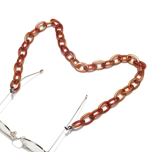 Detailed close-up of amber tortoiseshell acrylic eyewear chain with adjustable rubber loops