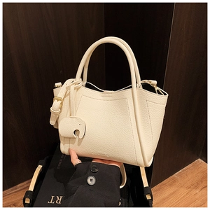 Detail of off-white pebble grain bucket bag with brand logo and elephant charm
