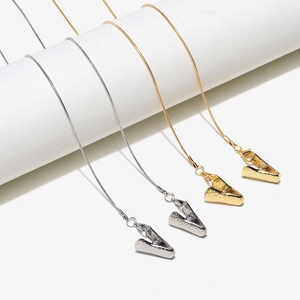 Detail of gold and silver snake chain lanyards with alligator clips on white podium