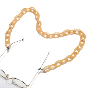 Amber resin eyeglass chain in heart shape with gold metal frames on white background