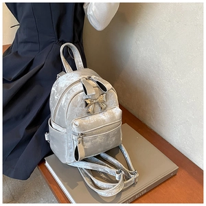 Détail du mini sac à dos en velours argenté avec nœud métallique et texture douce