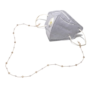 Golden handmade chain with stars and pearls for glasses and masks shown on a grey KN95 mask