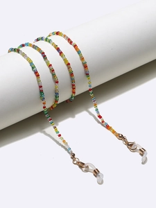 Detailed macro of colorful beaded eyeglass chain with golden lobster clasps and loops