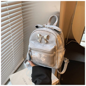 Détail d'un mini sac à dos argenté avec fini métallisé vintage et nœud en métal 3D