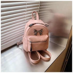 Détail du mini sac à dos rose avec nœud en métal argenté et similicuir texturé