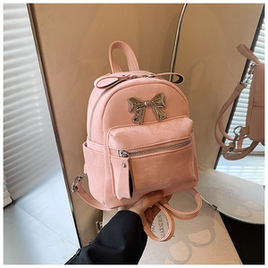 Détail du mini sac à dos rose avec noeud en métal argenté et texture en daim doux