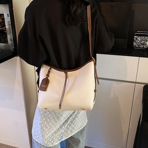 Sac fourre-tout chic en cuir beige avec bandoulières marron et clous de fond dorés