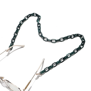 Détail de la chaîne de lunettes en acrylique vert foncé avec connecteurs en silicone
