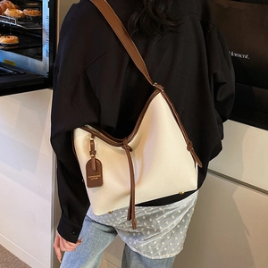 Grand sac cabas crème avec anses marron et texture cuir porté par un mannequin