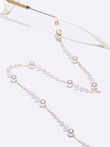 Detail of gradient pearl glasses chain featuring gold lobster clasps and silicone loops