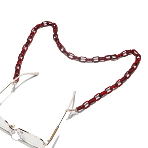 Détail macro de la chaîne de lunettes en acrylique ambre foncé avec connecteurs dorés