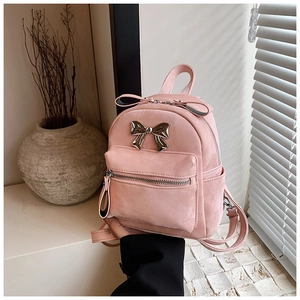 Détail du mini sac à dos en velours rose avec nœud métallique et poignée ruban