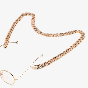 Detailed view of chunky golden curb chain glasses strap with adjustable silicone loop
