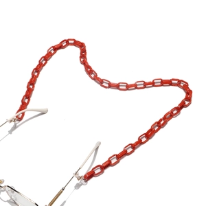 Détail de chaîne à lunettes rouge en acrylique avec clips dorés et boucles en silicone
