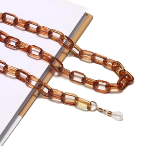 Détail d'une chaîne à lunettes en acrylique ambré avec clips métalliques et boucles