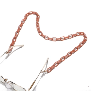 Détail de la chaîne de lunettes en acrylique rose avec crochets dorés et anneaux silicone