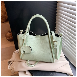 Close-up of mint green bucket bag with lychee grain texture and elephant charm