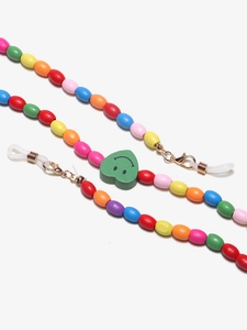 Detail of colorful wooden bead eyewear chain featuring a green heart smiley face charm