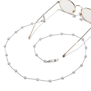 Détail de la chaîne de lunettes dorée avec perles de cœur et boucles réglables
