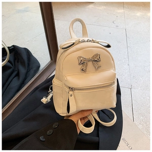 Détail du mini sac à dos crème avec nœud en métal argenté et cuir PU de qualité