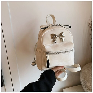 Détail du mini sac à dos en velours blanc crème avec un grand nœud argenté et fermeture éclair
