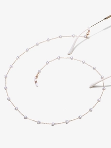 Détail de la chaîne de lunettes dorée avec perles en forme de cœur et boucles en silicone