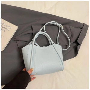 Detail of light blue lychee pattern leather bucket bag with metallic base studs