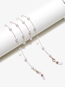 Détail d'une chaîne de lunettes dorée avec perles en cœur et boucles silicone