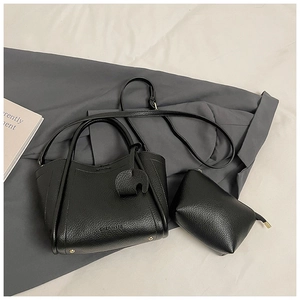 Close-up of black lychee grain leather bucket bag with brand logo and matching pouch