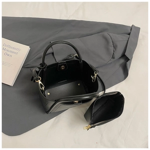 Interior view of black lychee grain bucket bag with matching zipper pouch and gold hardware