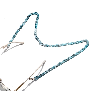 Dettaglio macro della catena per occhiali in acrilico marmorizzato blu con clip in metallo