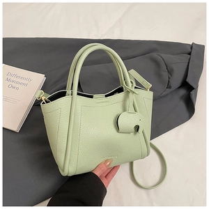 Close-up of mint green bucket bag with lychee texture and cute elephant charm