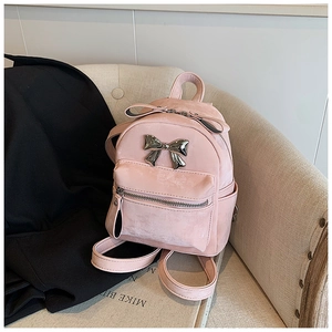 Détail d'un mini sac à dos rose avec nœud en métal argenté et texture mate douce