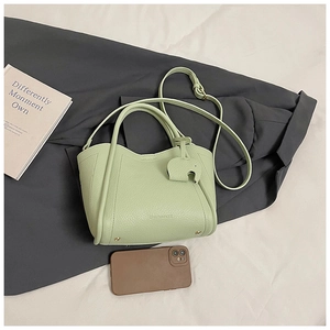 Detail of light green bucket bag with lychee texture and elephant charm accessory