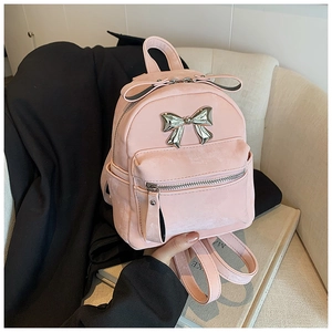 Détail du mini sac à dos rose en daim avec ornement de nœud en métal argenté