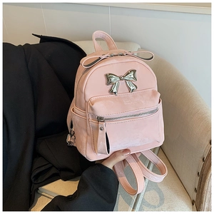 Détail du mini sac à dos en velours rose avec nœud argenté et texture soyeuse