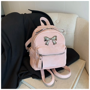 Détail du mini sac à dos rose avec nœud métallique argenté et texture en daim doux