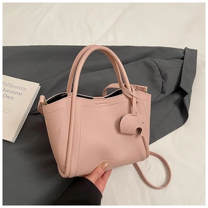 Pink lychee grain leather bucket bag with cute elephant charm and adjustable strap detail