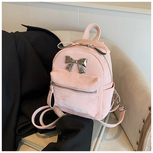 Détail du mini sac à dos en velours rose avec grand nœud décoratif en métal argenté
