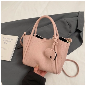 Pink lychee grain leather bucket bag with elephant charm and slender shoulder strap