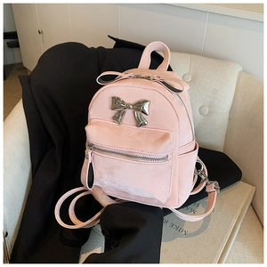 Détail d'un sac à dos rose mat avec nœud papillon en métal argenté et poche zippée