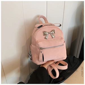 Détail du mini sac à dos rose avec texture en daim et nœud en métal argenté