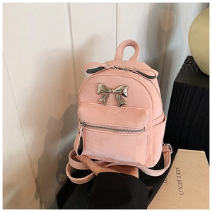 Détail du mini sac à dos rose clair avec nœud miroir argenté et texture en cuir PU lisse