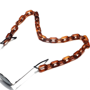 Détail de la chaîne de lunettes en acrylique écaillé avec boucles en caoutchouc noir