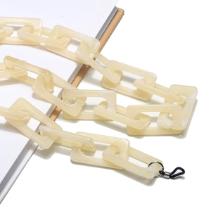 Dettaglio catena per occhiali in acrilico crema con maglie rettangolari e anelli in gomma
