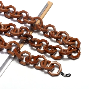 Detail of brown octagonal acrylic eyeglass chain with black and white rubber loops