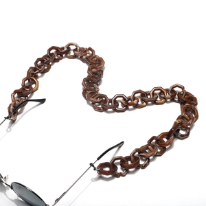 Detail of amber tortoiseshell acrylic eyeglass chain with hexagonal links and rubber grips